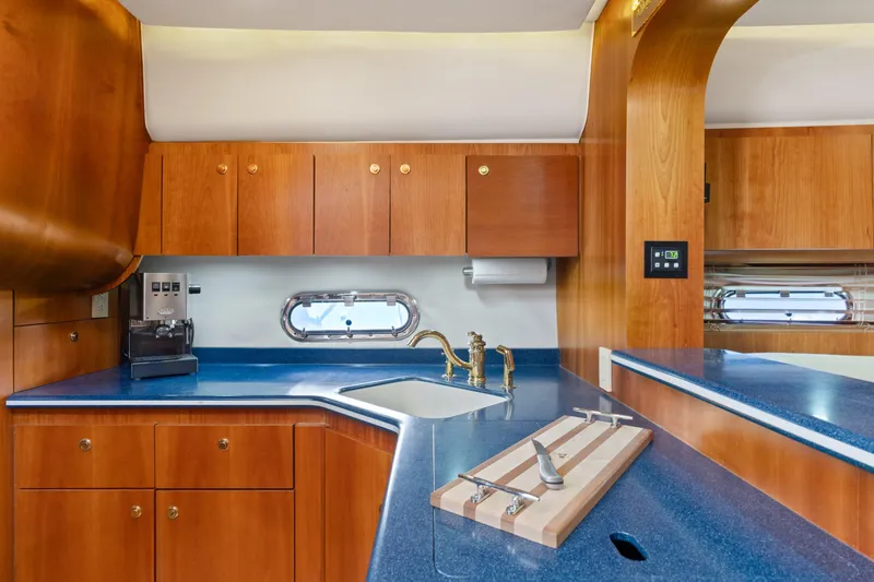 Cerulean Yacht Photos Pics Luxurious kitchen interior of 2000 Tiara Yachts 52 Express Cruiser with wood cabinetry.