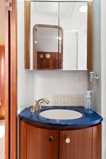 Cerulean Yacht Photos Pics Luxurious bathroom in 2000 Tiara Yachts 52 Express Cruiser with wooden cabinetry and blue countertop.