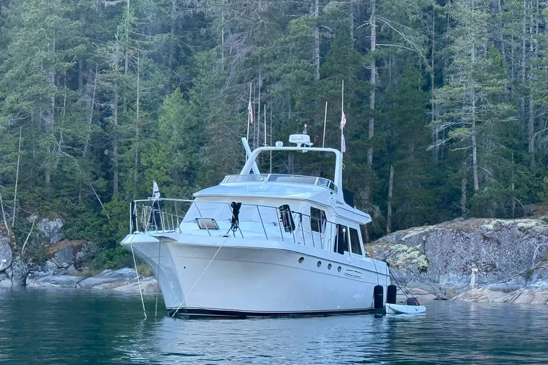 Gabbiano Yacht Photos Pics 2000 Navigator 53 yacht anchored in serene forested cove.