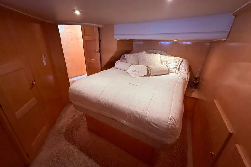 Gabbiano Yacht Photos Pics Luxurious bedroom interior of 2000 Navigator 53 yacht with cozy bedding and wooden finish.