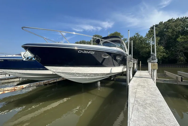  Yacht Photos Pics 2020 Formula 310SS boat docked on a lift, under a clear blue sky.