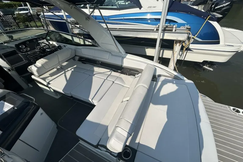  Yacht Photos Pics 2020 Formula 310SS boat interior with white seating and dashboard, docked beside another boat.