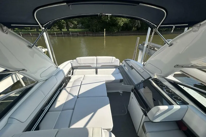  Yacht Photos Pics 2020 Formula 310SS boat interior with white seating and canopy, docked by a calm river.
