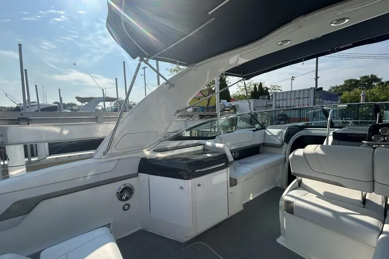  Yacht Photos Pics 2020 Formula 310SS boat interior with seating and canopy, docked under clear skies.