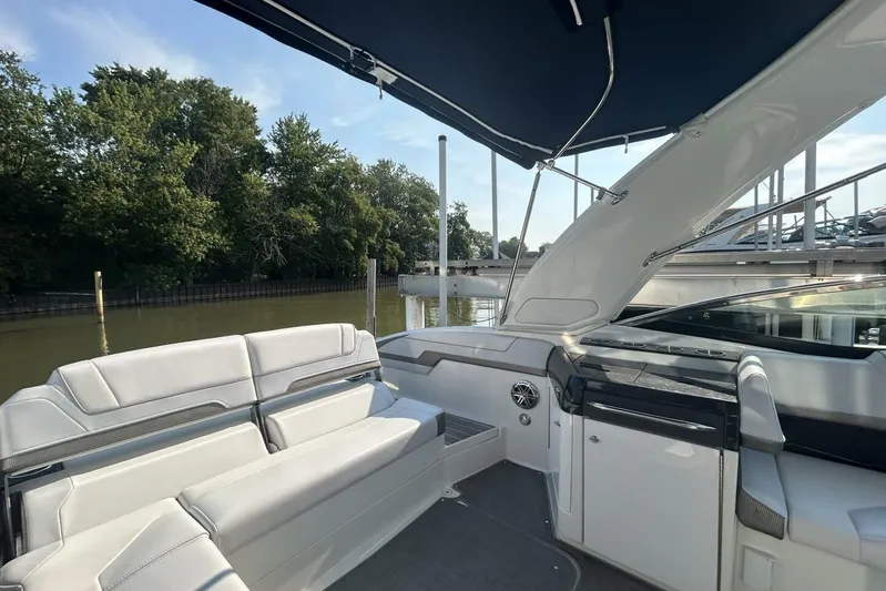  Yacht Photos Pics 2020 Formula 310SS boat interior with seating, docked by a serene waterfront.