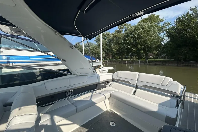  Yacht Photos Pics 2020 Formula 310SS boat interior with white seating, canopy, and waterfront view.