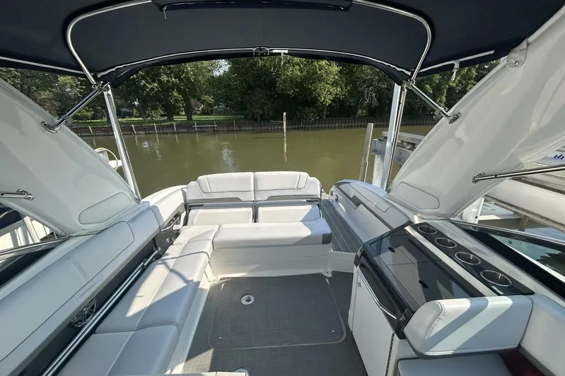 Yacht Photos Pics 2020 Formula 310SS boat interior with white seating and canopy, docked by a river.