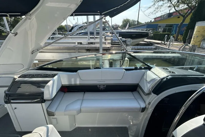  Yacht Photos Pics 2020 Formula 310SS boat interior with white seating and sleek design at a marina.