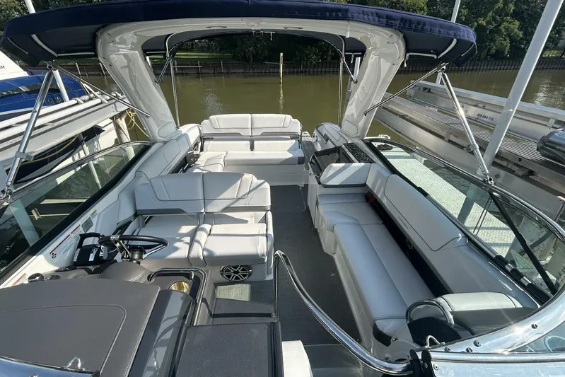  Yacht Photos Pics 2020 Formula 310SS boat interior with white seating and canopy, docked by a river.