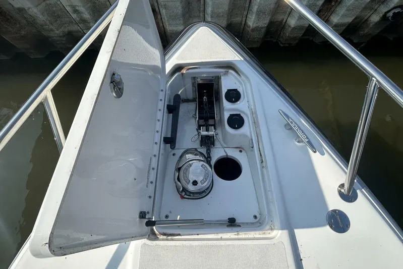  Yacht Photos Pics 2020 Formula 310SS boat anchor compartment with open hatch, docked by concrete wall.