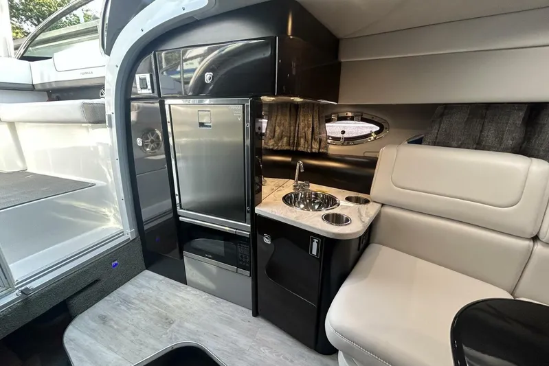  Yacht Photos Pics 2020 Formula 310SS boat interior with kitchenette, sink, and seating area.