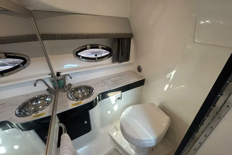  Yacht Photos Pics 2020 Formula 310SS boat bathroom with dual sinks, porthole, and toilet.