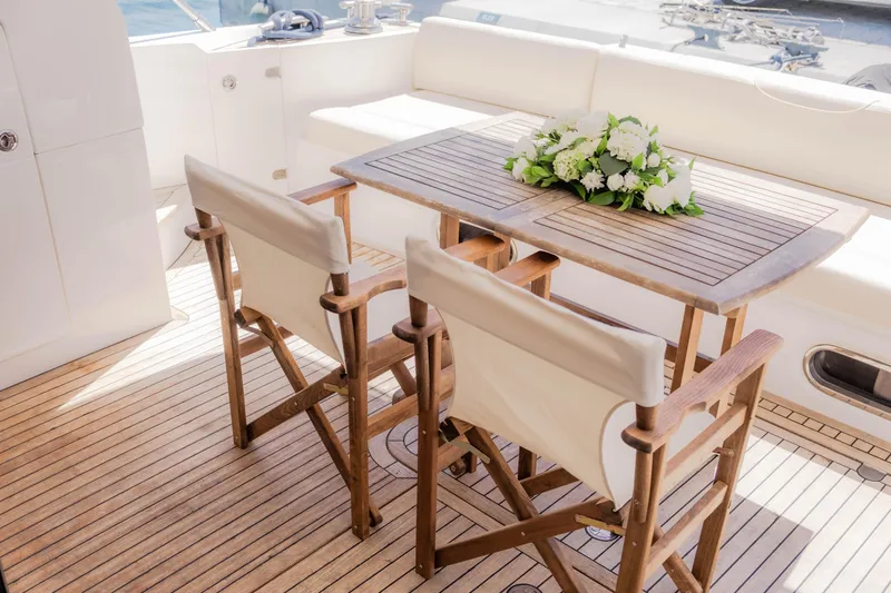  Yacht Photos Pics Luxurious 2008 Princess 62 Flybridge yacht deck with elegant wooden table and chairs.