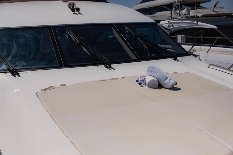  Yacht Photos Pics 2008 Princess 62 Flybridge yacht with towels on deck, docked in marina.