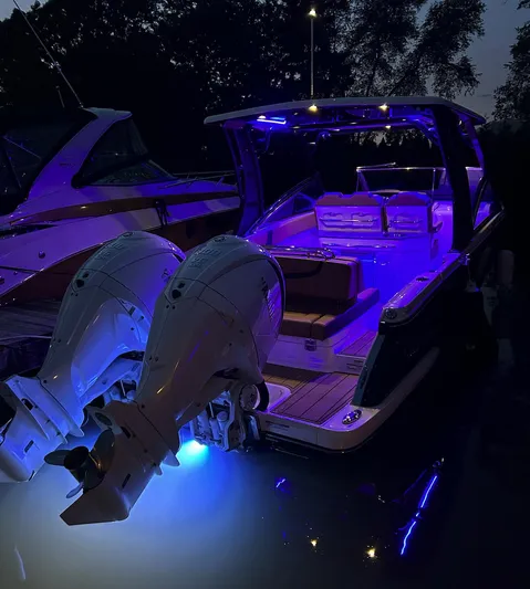  Yacht Photos Pics 2024 Chaparral 300 OSX boat illuminated with blue lights at night.