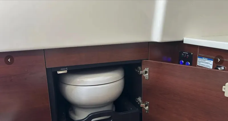  Yacht Photos Pics 2024 Chaparral 300 OSX boat interior with concealed toilet in wooden cabinet.