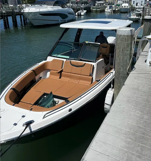  Yacht Photos Pics 2024 Chaparral 300 OSX boat docked, featuring sleek design and spacious seating.