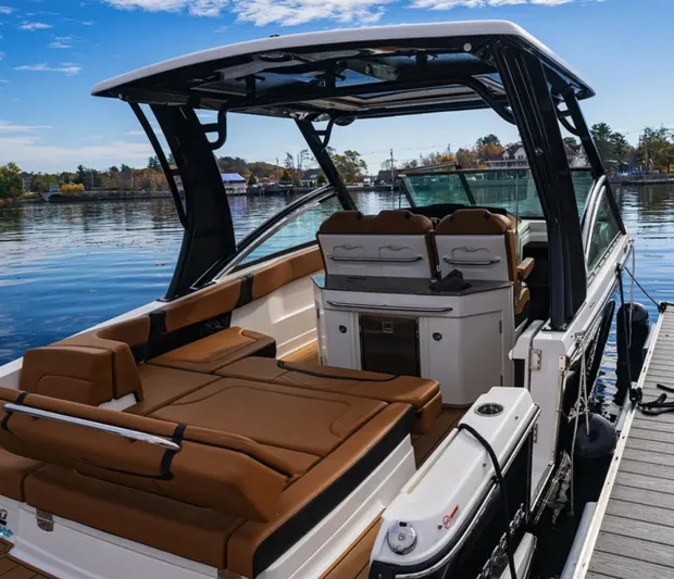  Yacht Photos Pics 2024 Chaparral 300 OSX boat with luxurious seating, docked on a calm lake.