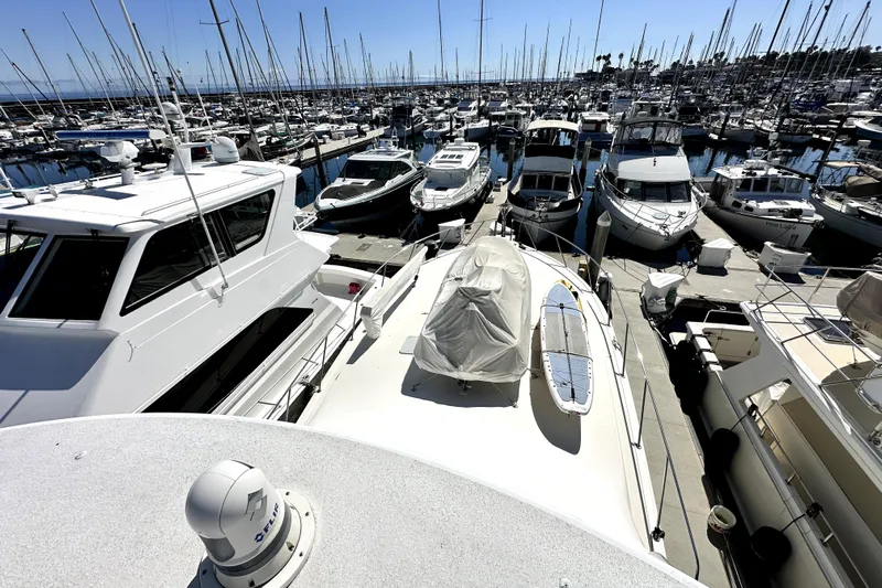Reel Inn Yacht Photos Pics Marina with numerous boats, including a 2003 Viking 61 Convertible yacht, docked under clear skies.