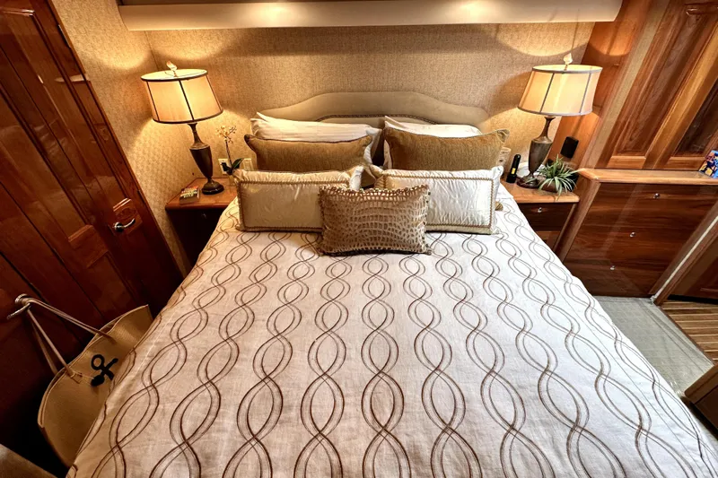 Reel Inn Yacht Photos Pics Luxurious bedroom interior of 2003 Viking 61 Convertible yacht with elegant bedding and warm lighting.