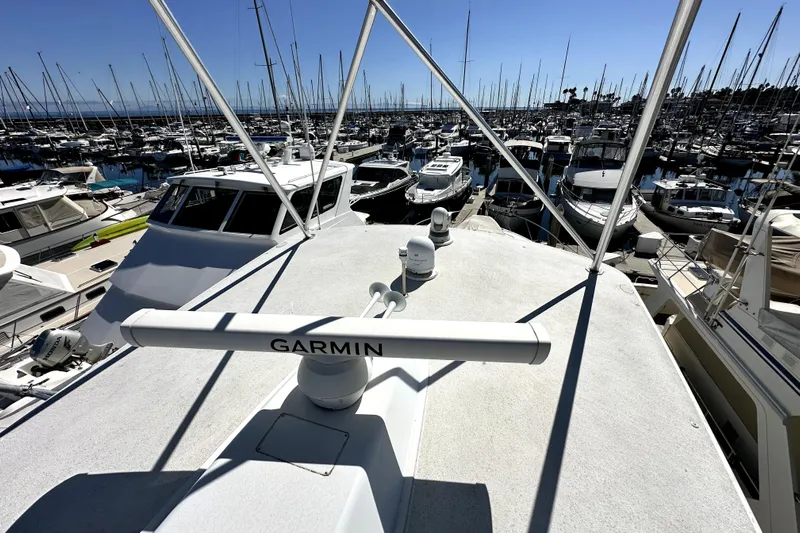 Reel Inn Yacht Photos Pics 2003 Viking 61 Convertible yacht in marina, featuring Garmin equipment, surrounded by boats.