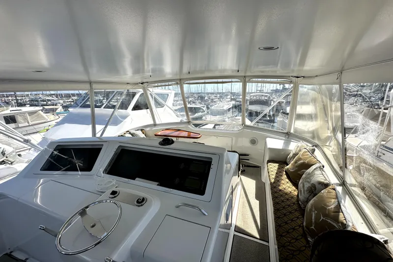 Reel Inn Yacht Photos Pics Interior view of 2003 Viking 61 Convertible yacht helm with marina backdrop.