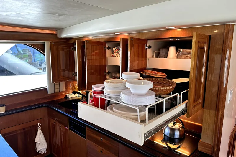 Reel Inn Yacht Photos Pics Luxurious kitchen interior of 2003 Viking 61 Convertible yacht with open cabinets.