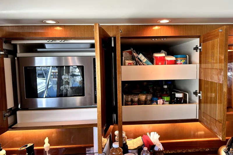 Reel Inn Yacht Photos Pics Kitchen cabinets in a 2003 Viking 61 Convertible yacht with microwave and pantry items.