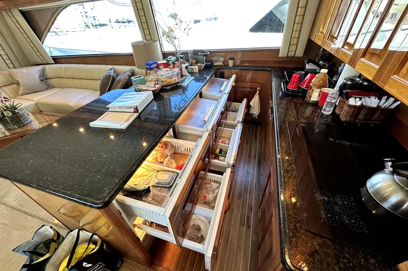 Reel Inn Yacht Photos Pics Luxurious kitchen interior of 2003 Viking 61 Convertible yacht with open drawers and modern amenities.