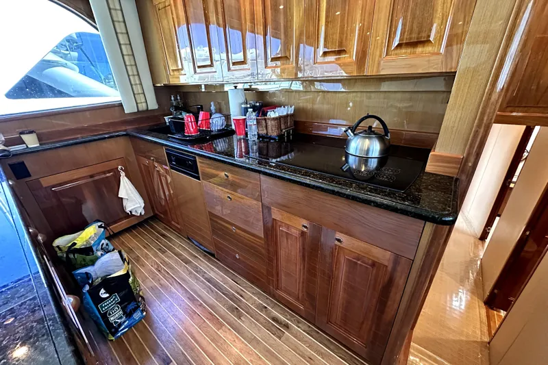 Reel Inn Yacht Photos Pics Luxurious kitchen interior of 2003 Viking 61 Convertible yacht with wooden cabinetry.