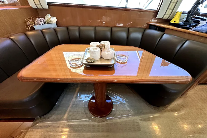 Reel Inn Yacht Photos Pics Luxurious dining area on 2003 Viking 61 Convertible yacht with elegant wood table and leather seating.