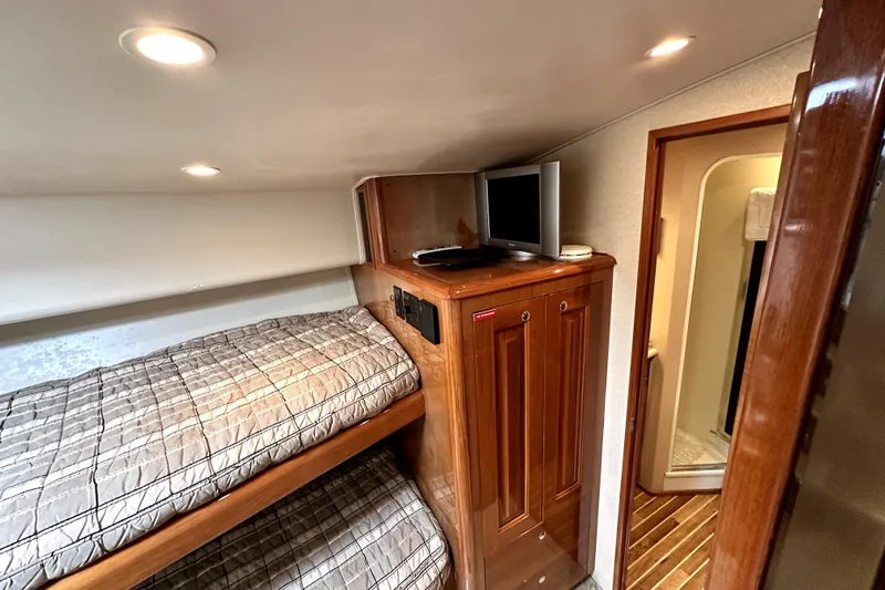 Reel Inn Yacht Photos Pics Interior of 2003 Viking 61 Convertible yacht with bunk beds and wooden cabinetry.