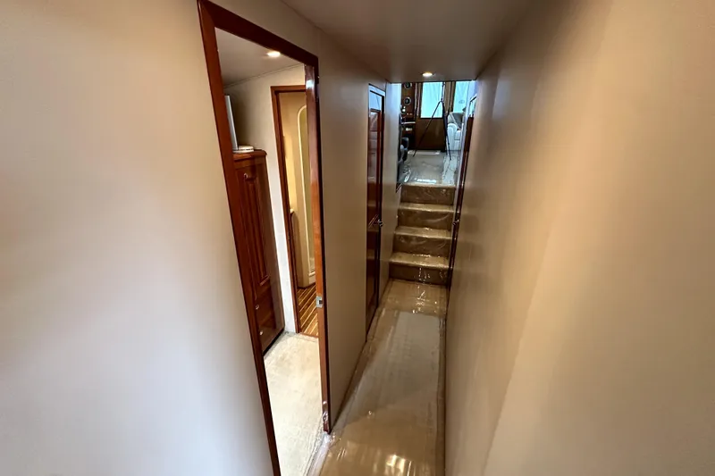 Reel Inn Yacht Photos Pics Narrow hallway inside 2003 Viking 61 Convertible yacht with wooden accents and stairs.