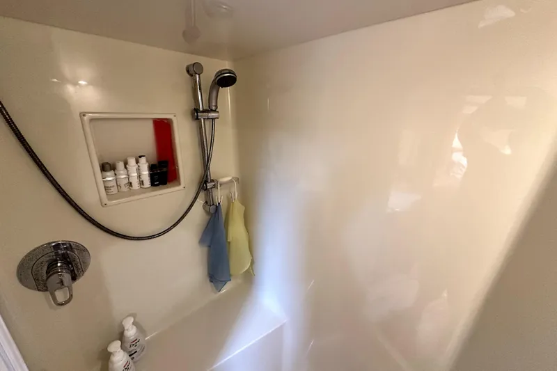 Reel Inn Yacht Photos Pics Shower area in 2003 Viking 61 Convertible yacht with toiletries and adjustable showerhead.