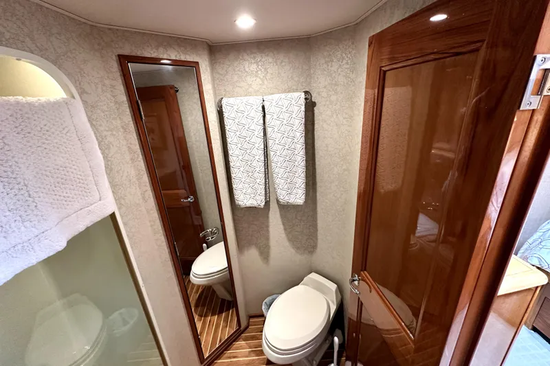 Reel Inn Yacht Photos Pics Bathroom interior of 2003 Viking 61 Convertible yacht with wooden accents and modern fixtures.