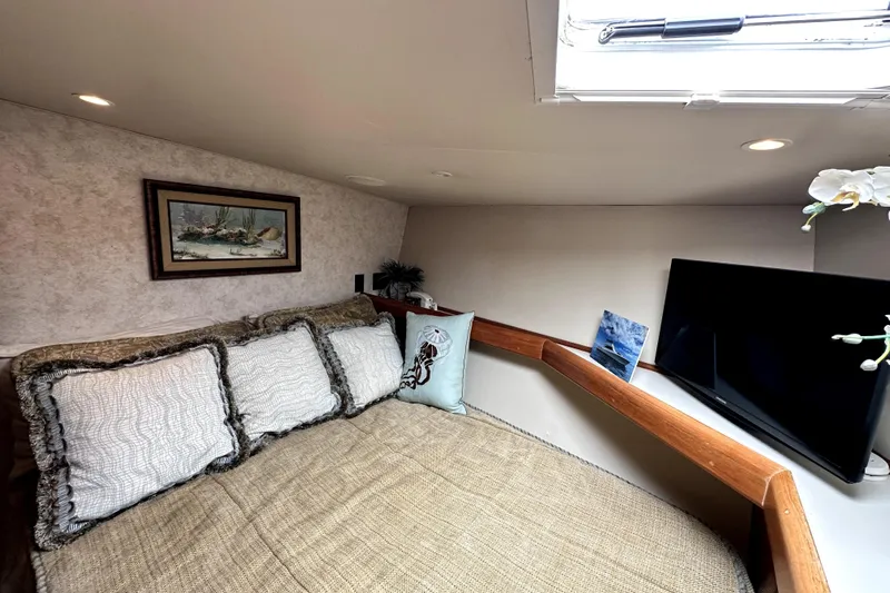 Reel Inn Yacht Photos Pics Cozy bedroom in 2003 Viking 61 Convertible yacht with TV and decorative pillows.