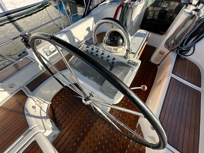 Pono Yacht Photos Pics Steering wheel and cockpit of 2006 Beneteau 423 sailboat with wooden deck.