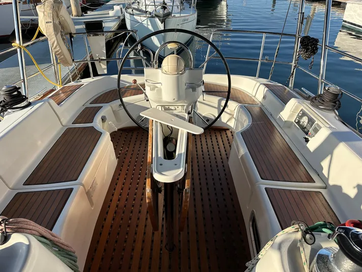 Pono Yacht Photos Pics Cockpit of a 2006 Beneteau 423 sailboat with wooden seating and steering wheel.