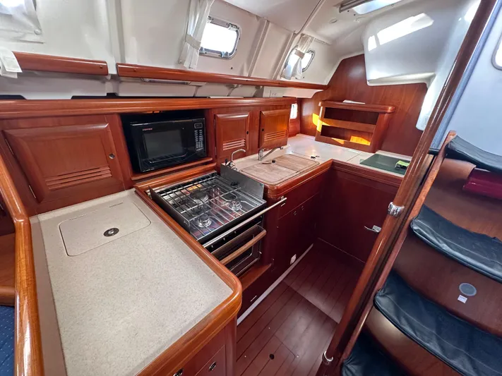 Pono Yacht Photos Pics Luxurious 2006 Beneteau 423 yacht kitchen with wood cabinetry and modern appliances.