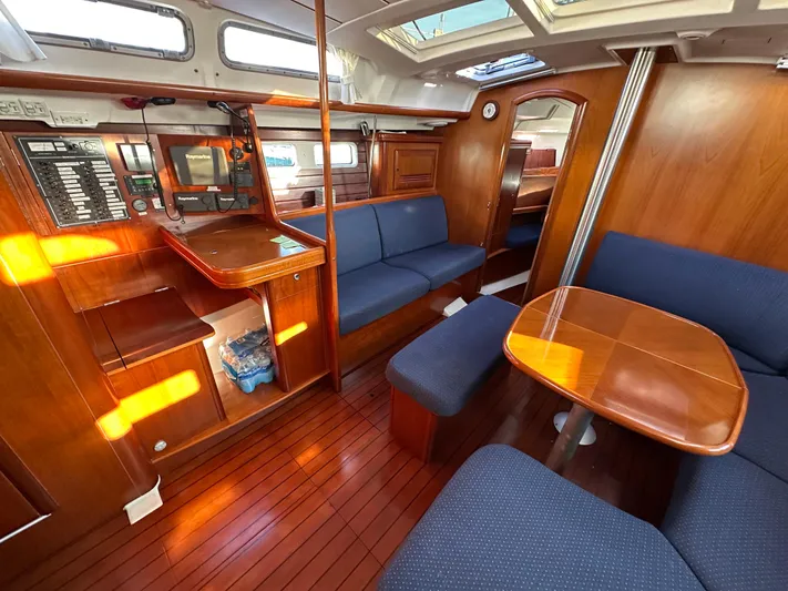 Pono Yacht Photos Pics Interior of 2006 Beneteau 423 sailboat with wooden furnishings and blue seating.