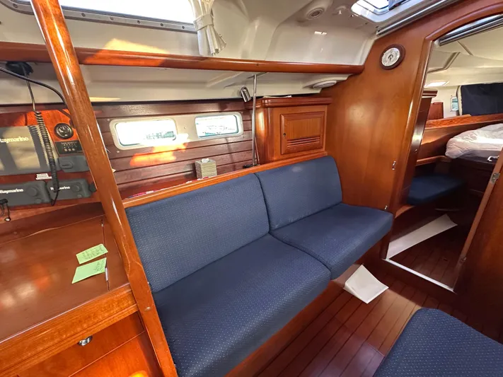 Pono Yacht Photos Pics Interior of 2006 Beneteau 423 sailboat with wooden finish and blue seating.