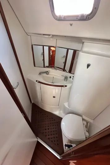 Pono Yacht Photos Pics 2006 Beneteau 423 yacht bathroom with sink, toilet, and mirror.