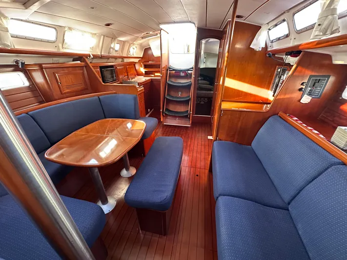 Pono Yacht Photos Pics Interior of 2006 Beneteau 423 sailboat with wooden finishes and blue seating.