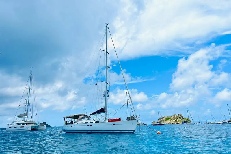  Yacht Photos Pics Sailboats anchored in clear blue waters, featuring a 2006 Beneteau 473 under a cloudy sky.