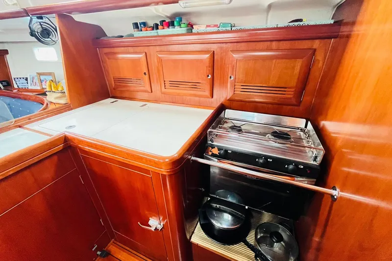  Yacht Photos Pics Interior of 2006 Beneteau 473 yacht kitchen with stove and wooden cabinetry.