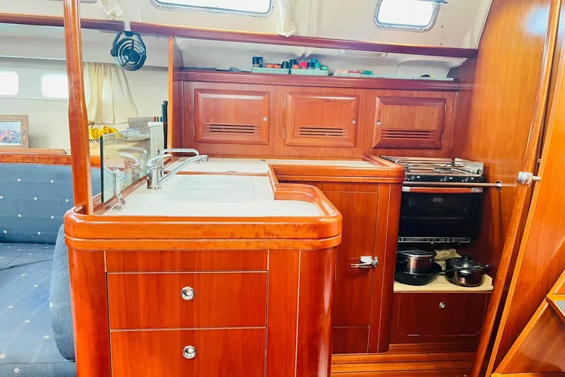  Yacht Photos Pics Interior of 2006 Beneteau 473 yacht, featuring a wooden galley with stove and storage.