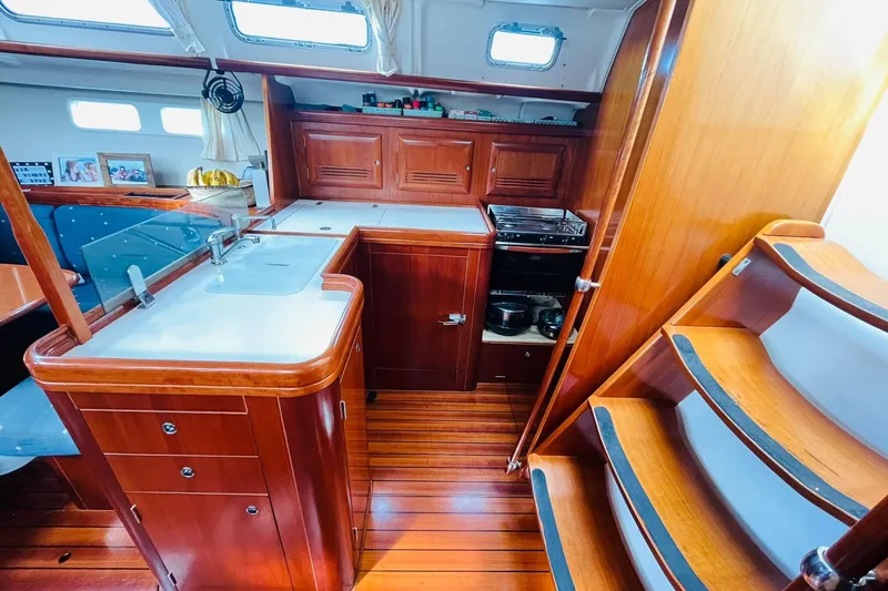 Yacht Photos Pics Interior of 2006 Beneteau 473 yacht, featuring a wooden kitchen and staircase.
