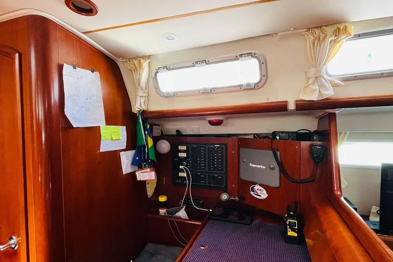  Yacht Photos Pics Interior of a 2006 Beneteau 473 sailboat with navigation equipment and wooden finish.