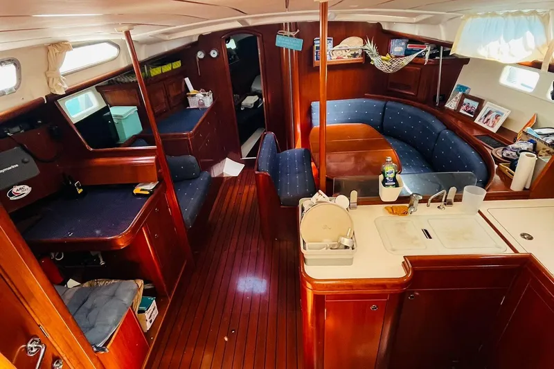  Yacht Photos Pics Interior of a 2006 Beneteau 473 sailboat with wood finish and cozy seating area.