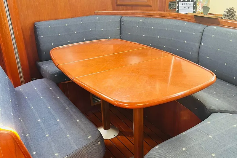  Yacht Photos Pics Interior of 2006 Beneteau 473 yacht with wooden table and cushioned seating.